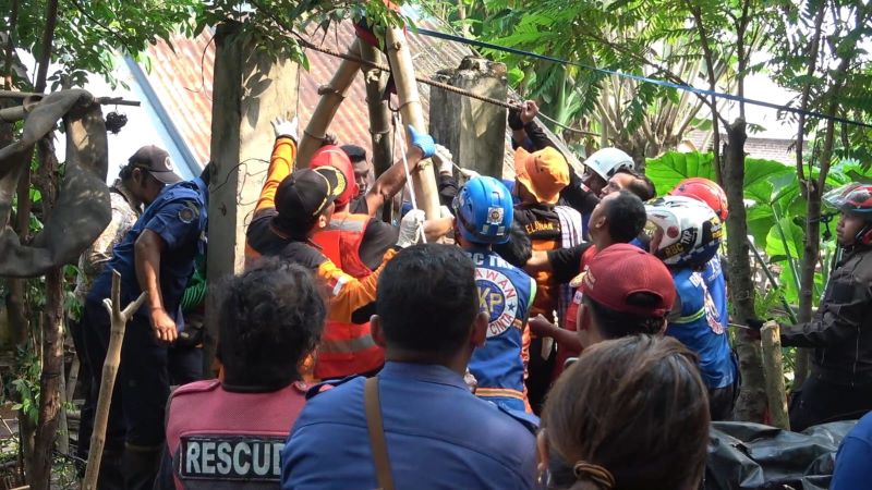 BIKIN GEGER: Petugas gabungan melakukan proses evakuasi korban dari dalam sumur, Kamis (26/6).