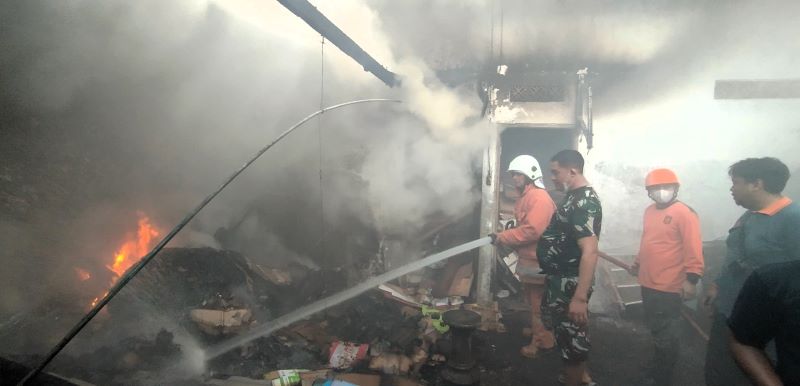 PENYEMPROTAN: Petugas damkar dibantu personel TNI dan Polri berjibaku memadamkan api yang melalap toko elektronik di kompleks Pasar Dlanggu, Desa/Kecamatan Dlanggu, Minggu (29/6) sore.
