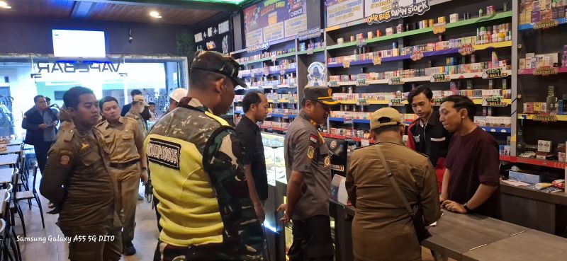 DIBERANTAS: Petugas Satpol PP Kota Mojokerto bersama tim gabungan saat melakukan operasi pemberantasan barang kena cukai ilegal di salah satu toko kelontong, Senin (30/6).