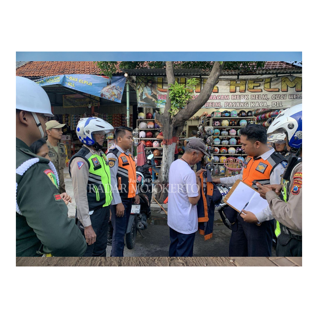 DILUCUTI: Petugas menyita seragam resmi yang dipakai jukir liar di Jalan PB Sudirman, Kota Mojokerto, Senin (30/6).