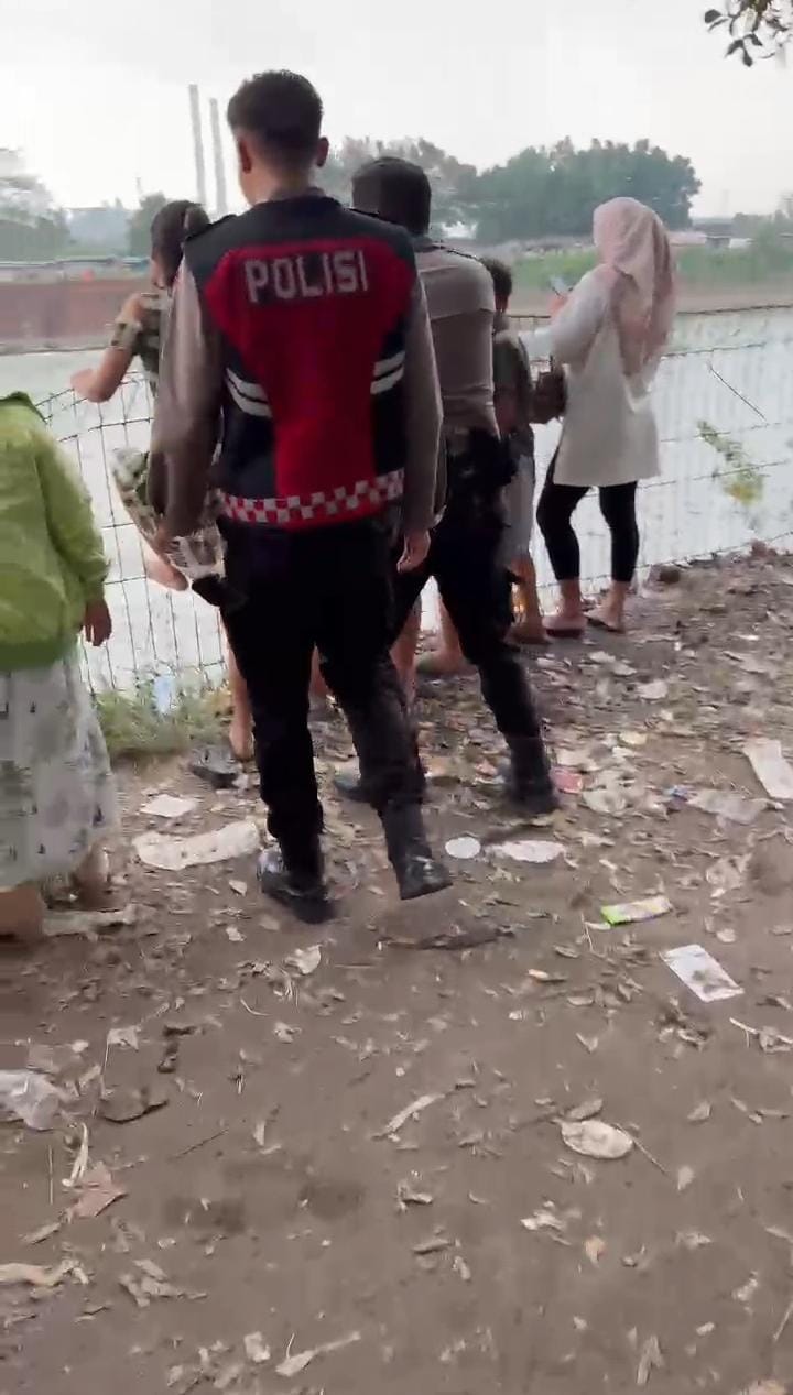 TAK PATUT DITIRU: Seorang warga diamankan petugas kepolisian saat berusaha melompat ke Sungai Brantas di kawasan Dam Rolak Songo, Kamis (3/7) sore.