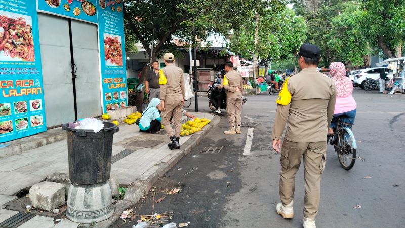DIKELUHKAN: Petugas Satpol PP Kota Mojokerto memberi imbauan kepada PKL di Jalan HOS Cokroaminoto, kemarin (3/7).