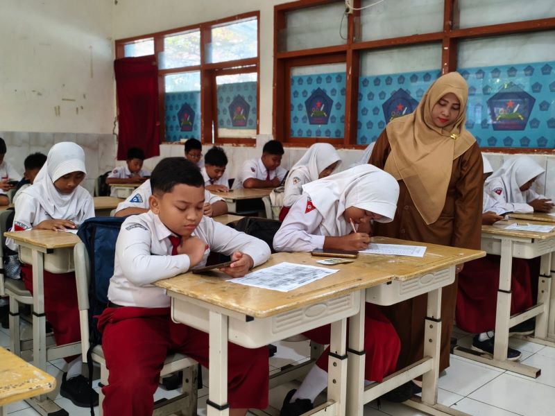 HUMANIS: Siswa baru SMPN 5 Mojokerto diawasi pendamping dan guru BK saat menjalani placement tes, Selasa (8/7).