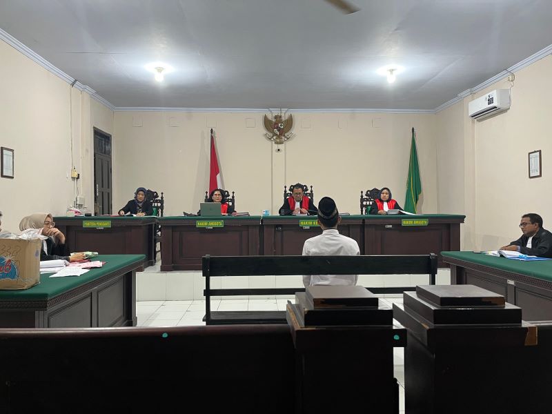 TERSENYUM: Terdakwa pembunuhan, Sudarwo alias Jarwo, digelandang petugas kejaksaan untuk menjalani sidang di Pengadilan Negeri Mojokerto.