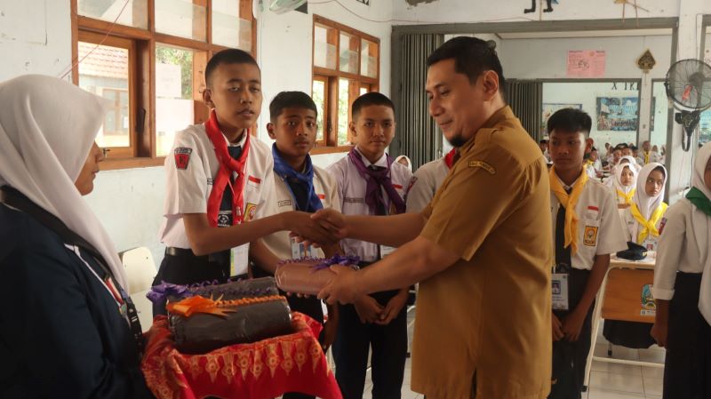 SAMBUT SISWA: Kepala SMKN 1 Mojoanyar 1 Hidayat menyematkan kartu tanda peserta pada siswa baru saat pembukaan MPLS.