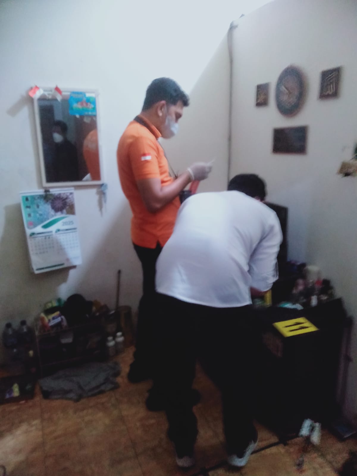 OLAH TKP: Petugas kepolisian melakukan olah TKP penemuan mayat di dalam kamar kos di Desa Wonosari, Kecamatan Ngoro, Senin (21/7).