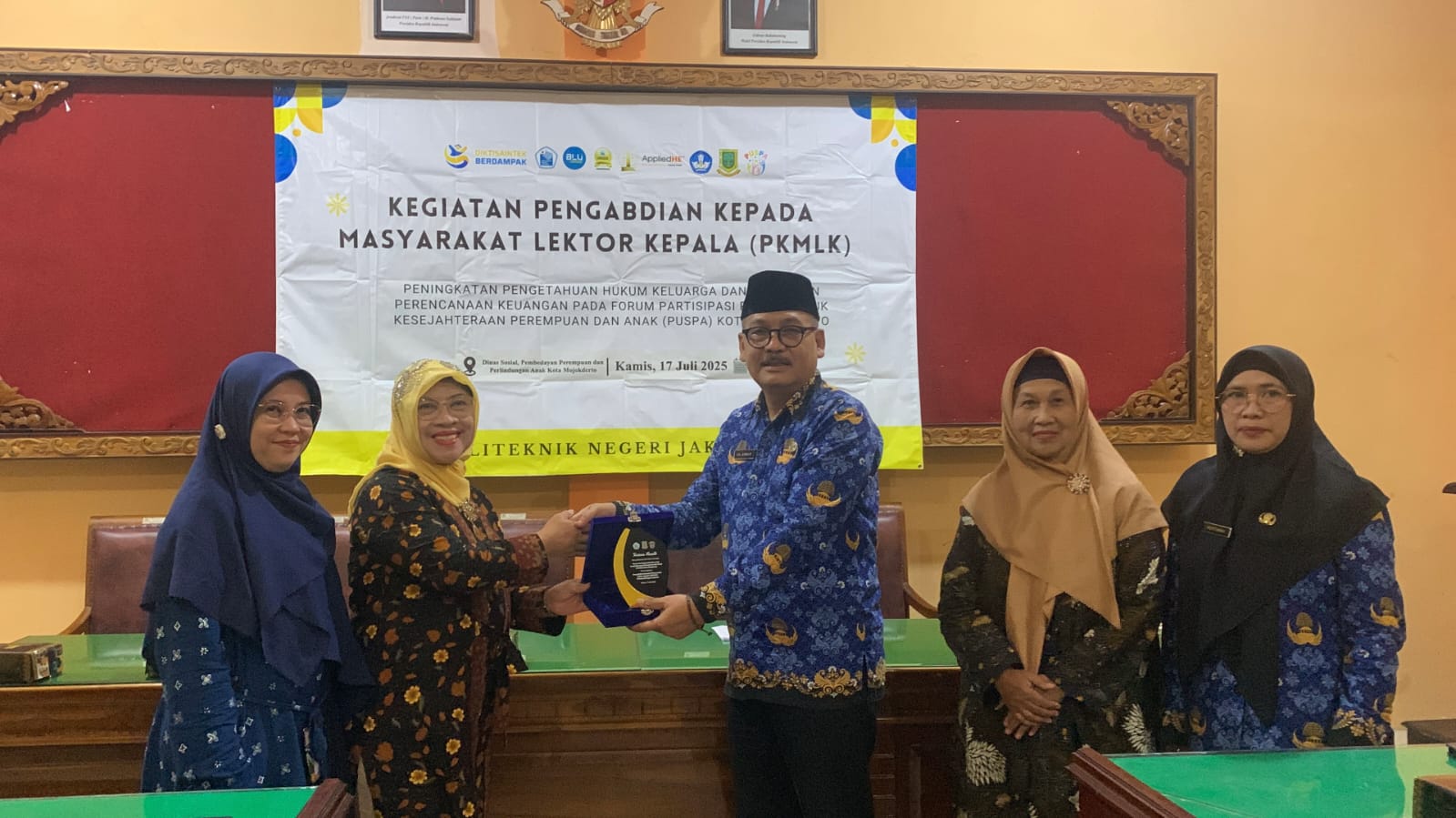 SINERGI: Dr. Ida Nur Hidayati, SH, MH dari Politeknik Negeri Jakarta memberikan kenang-kenangan kepada Kadinsos Kota Mojokerto Choirul Anwar selepas pelatihan di aula setempat, Kamis (17/7) lalu.