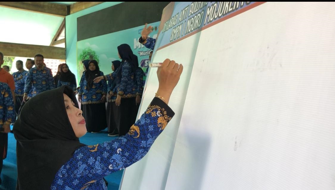 KOMITMEN: Kepala SMPN 1 Ngoro Sri Indayani menandatangani deklarasi stop bullying dan antikekerasan saat pelaksanaan MPLS pekan kemarin.