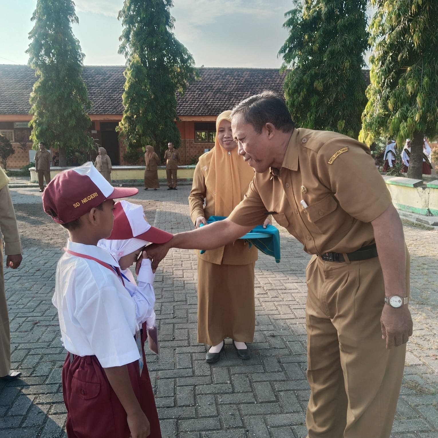 RAMAH: Kepala SDN Sumberwuluh Jais menyambut kedatangan peserta didik baru saat pembukaan MPLS, Senin (14/7).