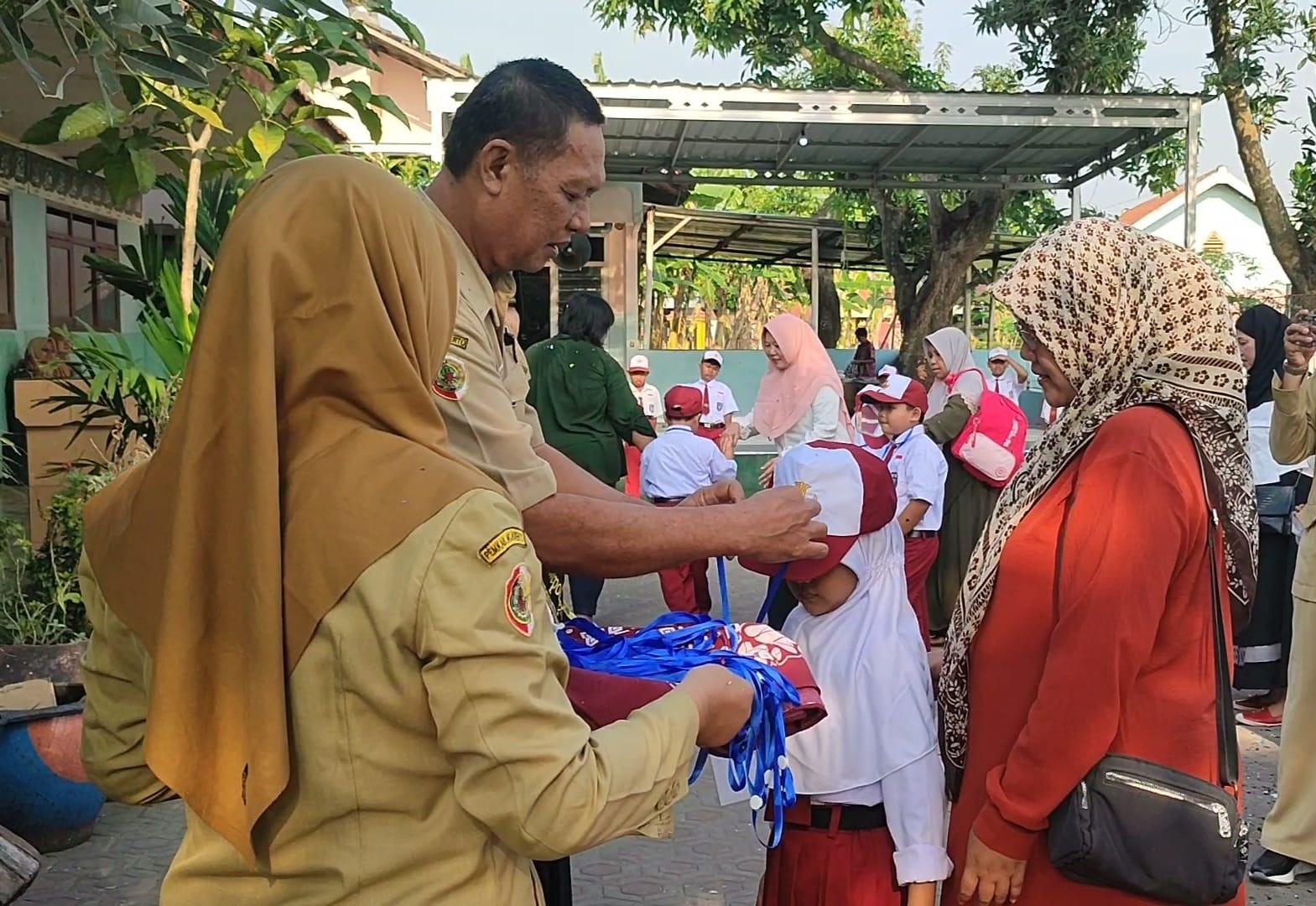 RESMI BERGULIR: Kepala SDN Gempolkerep Hariono menyematkan topi dan tanda pengenal pada perwakilan peserta MPLS.