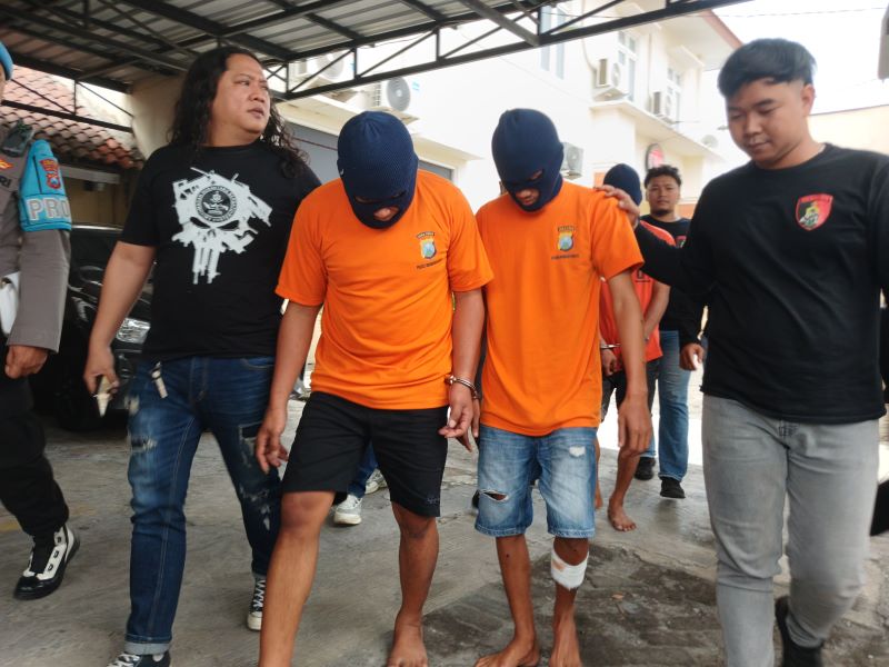 TERPINCANG-PINCANG: Dua tersangka curanmor digiring ke ruang tahanan Mapolres Mojokerto Kota, kemarin (24/7).