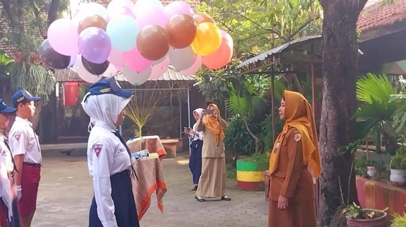 DITERIMA: Kepala SMPN 2 Kutorejo Rahayu Wijayati menyematkan tanda peserta kepada siswa baru saat pembukaan MPLS.