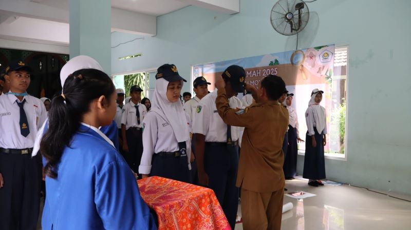 PENUH MAKNA: Kepala SMAN 1 Mojokerto Subandi menyematkan tanda kepesertaan MPLS pada siswa baru.