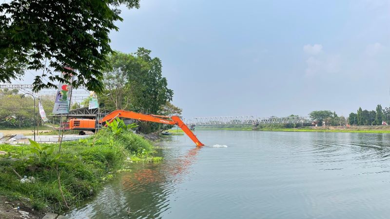 DISENTUH LAGI: Satu unit backhoe diterjunkan di kawasan MKP Brantas, Desa Mlirip, Kecamatan Jetis, untuk membersihkan semak-semak, eceng gondok, hingga membuat tanggul.