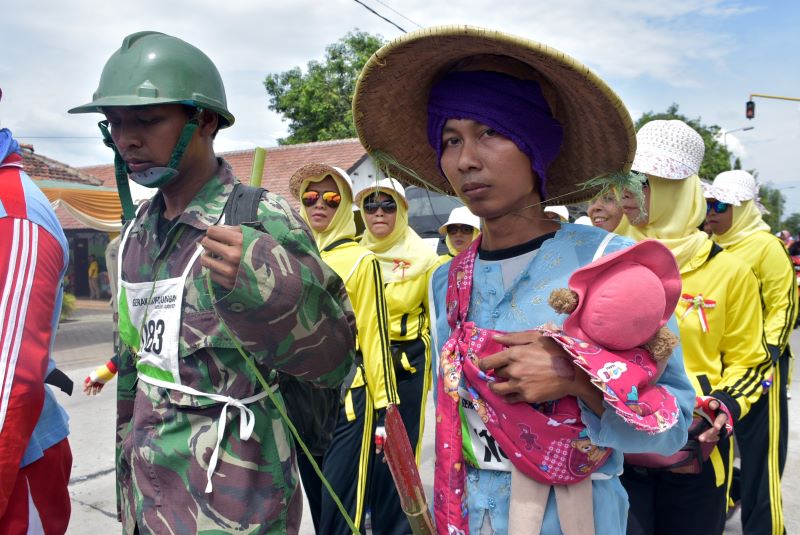 TELADANI PAHLAWAN: Peserta gerak jalan menggunakan atribut pejuang dalam event Gerak Jalan Mojosari-Mojokerto.