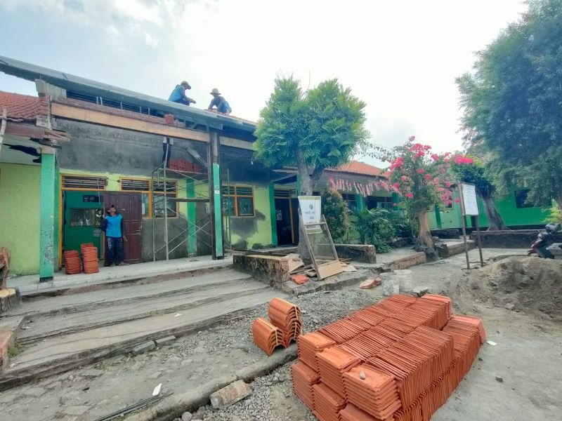 DIKEBUT: Pekerja tengah menaikkan genting pada salah satu ruang kelas di SDN Kupang 2, Kecamatan Jetis, dalam rehabilitasi tahun anggaran 2025, kemarin (7/8).