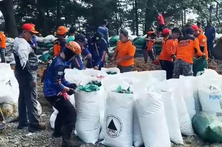 PEDULI: Relawan dari berbagai organisasi kebencanaan gotong royong membersihkan jalur penyelamatan di turunan rest area Sendi, Desa/Kecamatan Pacet, kemarin (8/8).