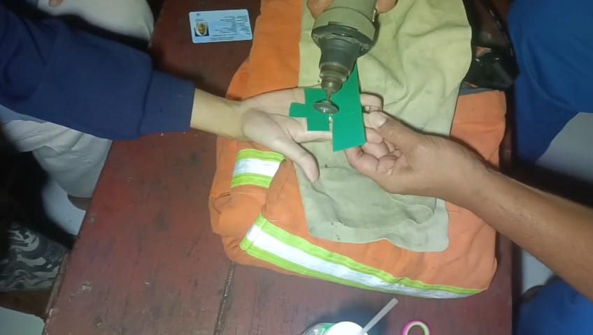 DIGERINDA: Petugas Damkar Kota Mojokerto memotong cincin yang tersangkut di jari warga, Sabtu (10/8).
