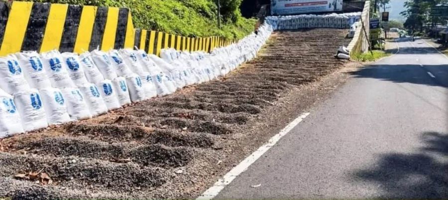 TEKAN FATALITAS: Pekerja memasang karung sekam di jalur ekstrem Pacet-Cangar, Desa/Kecamatan Pacet, Kabupaten Mojokerto, Sabtu (9/8).