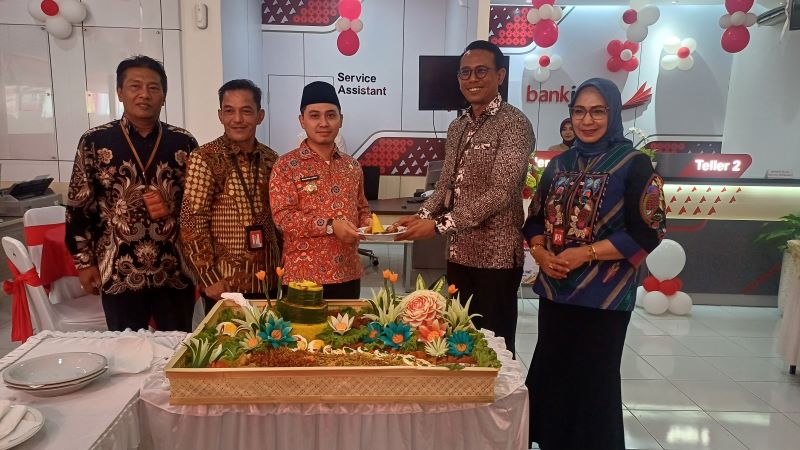 SIMBOLIS: Bupati Mojokerto Muhammad Albarraa memberikan potongan tumpeng pertama kepada Pemimpin Cabang Pembantu Jetis Miryadi Mukti Widodo saat pembukaan Bank Jatim Cabang Pembantu Jetis, kamis (14/8