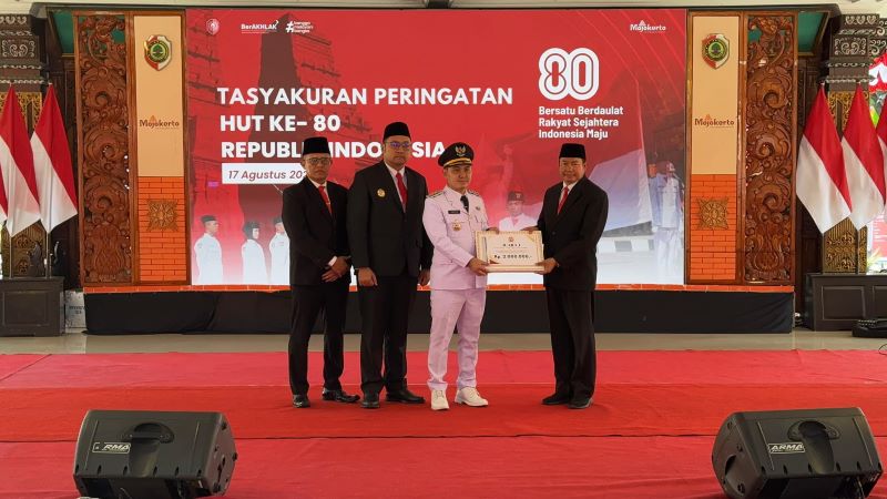 INOVATIF: Bupati Mojokerto Muhammad Albarraa didampingi Wabup Mojokerto M. Rizal Oktavian dan Sekdakab Teguh Gunarko, menyerahkan hadiah Kepala Dispendukcapil Amat Susilo atas inovasinya melayani.