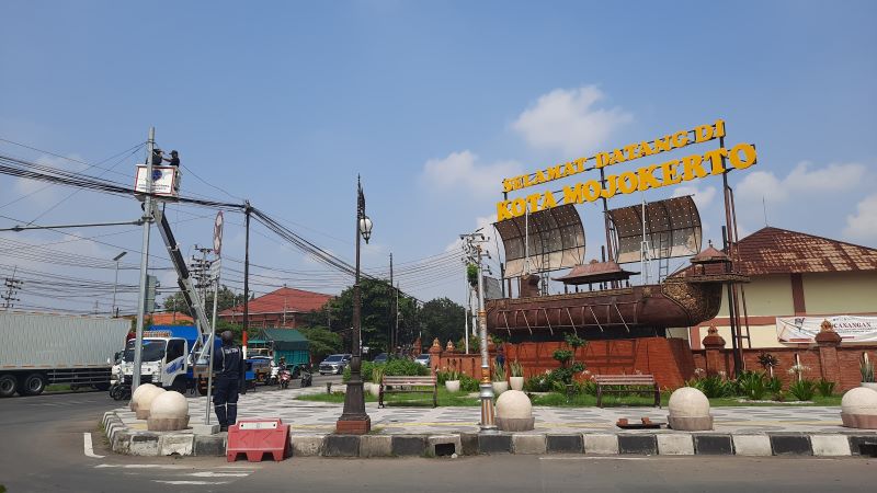 FASILITAS UMUM: Petugas Dishub Kota Mojokerto memasang lampu penerangan di simpang empat Sekarputih, Kecamatan Magersari.