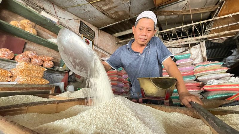 DIKELUHKAN: Pedagang beras di Pasar Tanjung Anyar, Kota Mojokerto, saat melayani pembeli, kemarin (21/8). Hingga kini penjualan bahan pokok tersebut belum menunjukkan kondisi membaik.