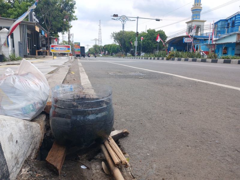 DIBIARKAN: Kondisi lubang drainase di Jalan Empunala, Kota Mojokerto, yang ditutup sekenanya, kemarin (28/8).