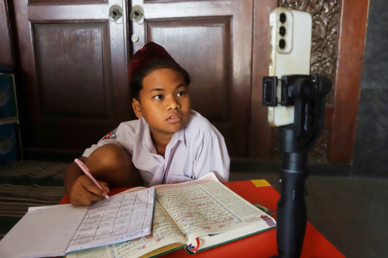MENDAPAT TUGAS: Salah satu siswa madrasah di Jalan Raya Surodinawan Kota Mojokerto menerapkan pembelajaran daring akibat sekolahnya berdekatan dengan kawasan yang rawan sasaran aksi demonstrasi.
