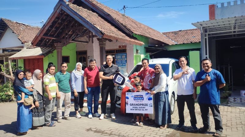 SENANG: Ryan Kosasih Raharja, Pemimpin BRI Cabang Mojokerto (kaos hitam) memberikan secara langsung grand prize 1 unit mobil Suzuki All New Ertiga GL M/T kepada nasabah di Pungging.