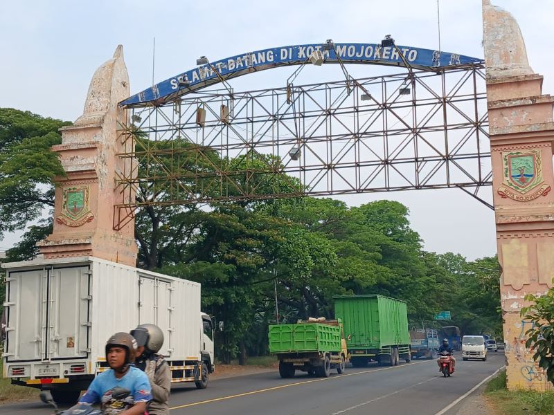 BERBAHAYA: Pengendara melintas di bawah rangka besi reklame bando di gapura selamat datang Kota Mojokerto, Jalan Bypass, Kecamatan Magersari, kemarin (8/9).