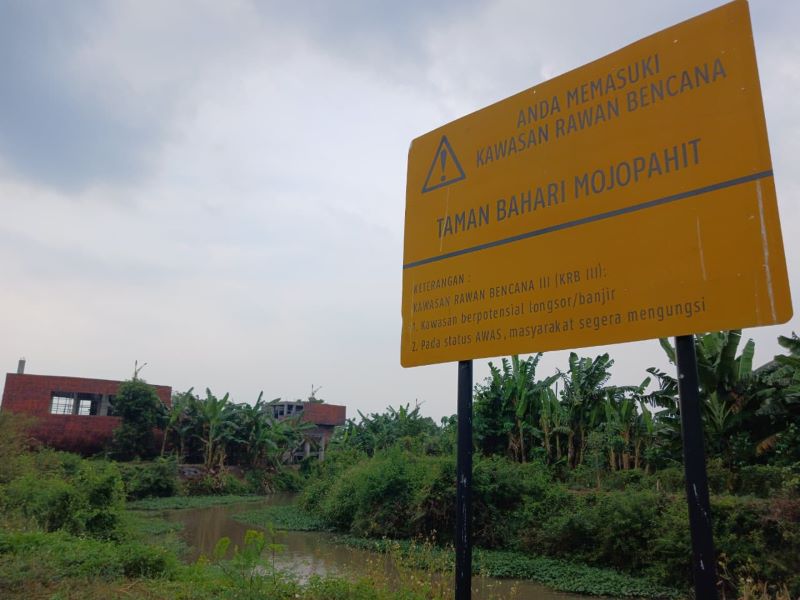 RAWAN BENCANA: Papan peringatan rawan bencana banjir dan longsor di tepi sungai kawasan TBM, Kecamatan Prajurit Kulon, Kota Mojokerto, kemarin (9/9).
