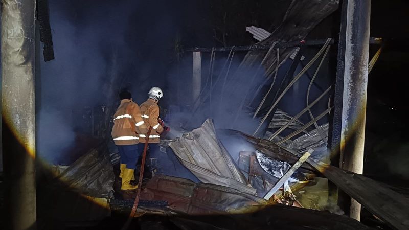 LUDES: Petugas damkar melakukan pembasahan area kandang sapi yang dilalap api, Selasa (9/9) malam.