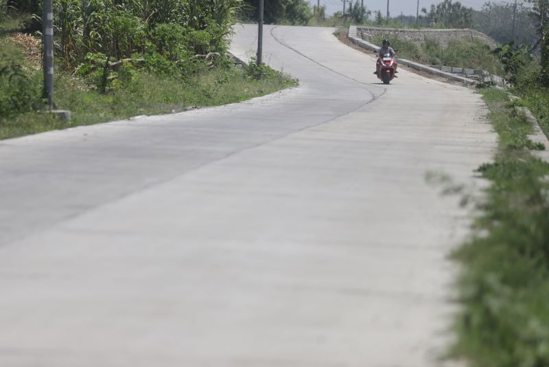 MULUS DAN NYAMAN: Pengendara melintas di jalan cor Kepuhanyar-Ngimbangan, Kecamatan Mojoanyar, kemarin (12/9).