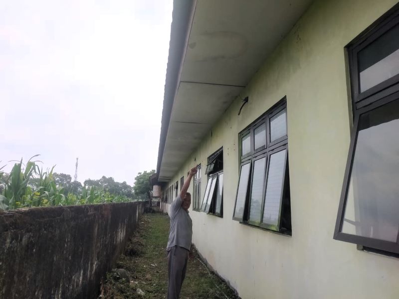RAIB: Petugas keamanan Puskesmas Puri menunjukkan lokasi AC outdoor yang raib dicuri, kemarin (15/9).