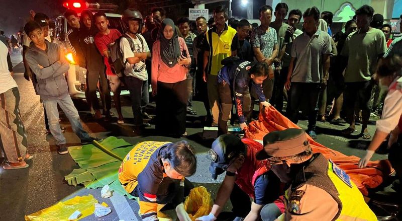 TRAGIS: Petugas mengevakuasi jasad korban kecelakaan di Jalan Raya Desa Mojokumpul, Kecamatan Kemlagi, Rabu (17/9) malam.