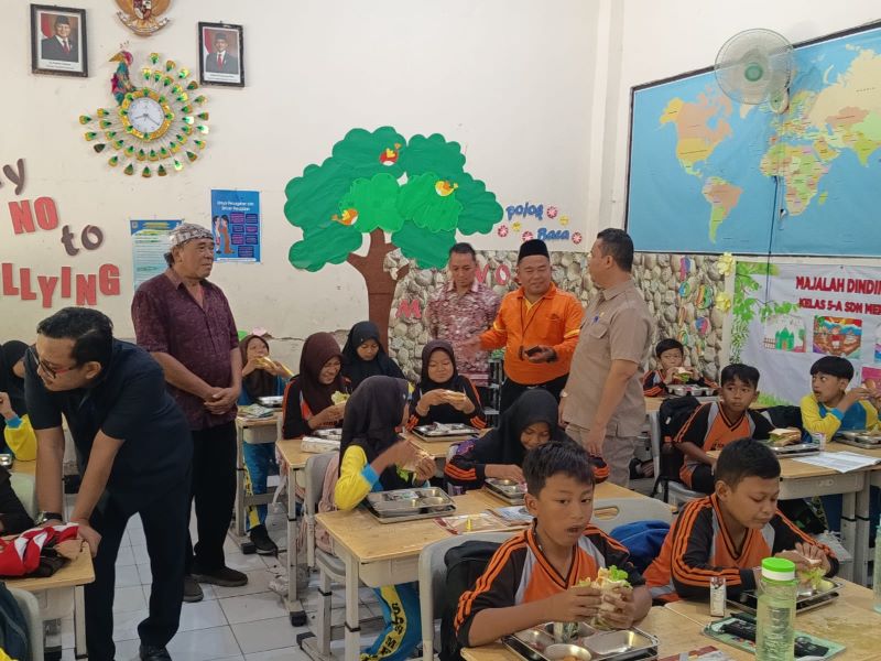 PASTIKAN BERGIZI: Anggota Komisi III DPRD Kota Mojokerto melihat langsung distribusi dan menu MBG yang disantap para siswa di SDN Meri, Kelurahan Meri, Kecamatan Kranggan, kemarin (19/9).