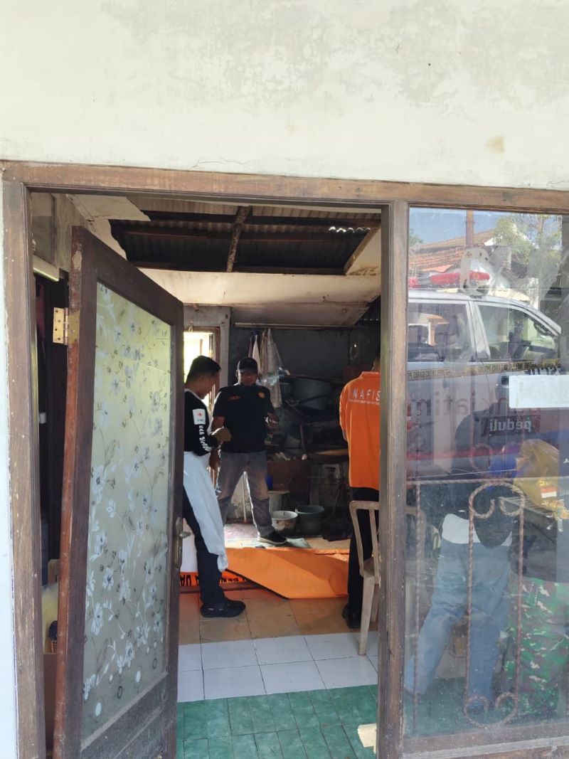 DITANGANI: Proses evakuasi jenazah yang ditemukan membusuk di rumahnya di Jalan Raya Desa Kalen, Kecamatan Dlanggu, Jumat (19/9).