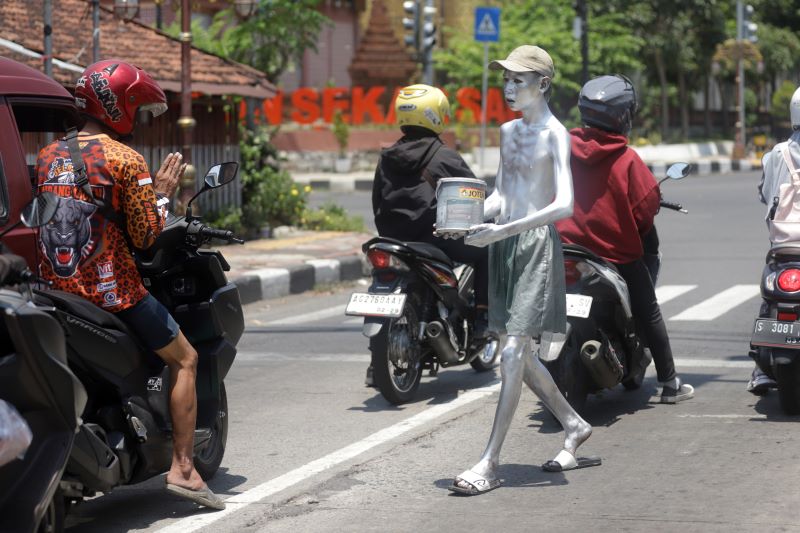 BANDEL: Aktivitas manusia silver di simpang empat Pemandian Sekarsari, Jalan Empunala, Kota Mojokerto, kemarin (23/9).