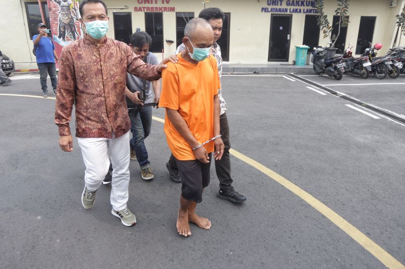 TEGA: Elyas Yasak, 50, terdakwa perkara pencabulan anak saat digelandang menuju tahanan Mapolres Mojokerto Kota April lalu.