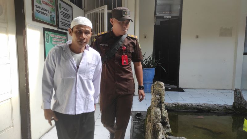 TEGA: Dodik Hermawan, terdakwa kasus kekerasan anak sebelum menjalani sidang perdana di Pengadilan Negeri Mojokerto kemarin.