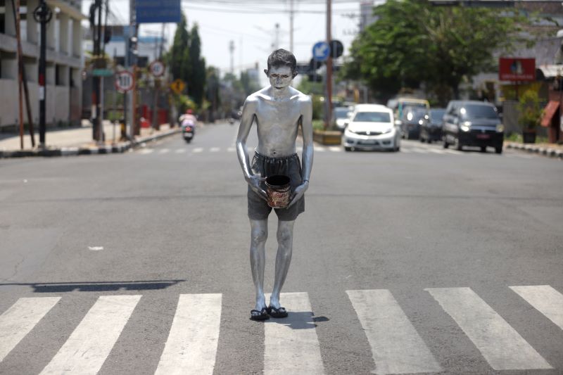 LANGGANAN DICIDUK: Pengemis manusia silver beroperasi di simpang empat Sekarsari, Jalan Gajah Mada, Kota Mojokerto, beberapa waktu lalu. Mereka kembali beraktivitas meski berkali-kali terjaring razia.