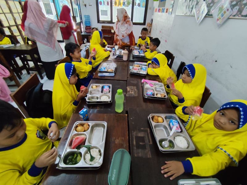 LEZAT DAN BERGIZI: Siswa SD Muhammadiyah Plus menikmati menu MBG yang telah berjalan selama dua pekan di jam istirahat pertama, kemarin (3/10).