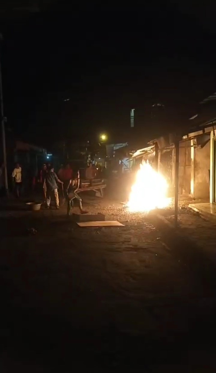 MEMBARA: Warga berupaya memadamkan api dari kebocoran pipa gas di kompleks Pasar Niaga, Kelurahan Sawahan, Kecamatan Mojosari, Jumat (3/10).