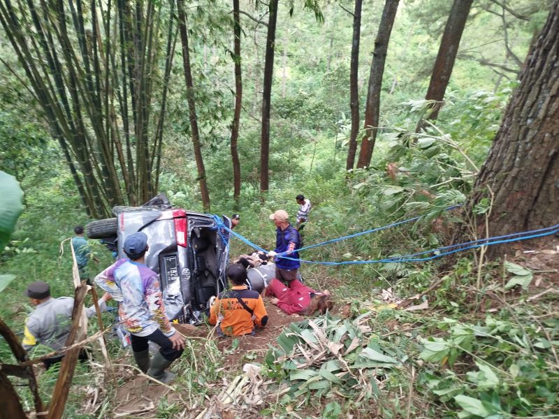 DIEVAKUASI: Petugas dibantu warga dan relawan berjibaku mengevakuasi mobil yang terjun ke jurang tepi Jalur Pacet-Cangar, Minggu (5/10).