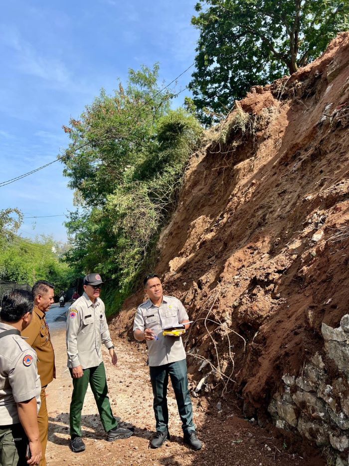 CEK LOKASI: Petugas BPBD Kabupaten Mojokerto mengecek titik longsor di tepi Jalan Raya Dusun Kambengan, Desa Cepokolimo, Kecamatan Pacet, beberapa waktu lalu.&nbsp;&nbsp;