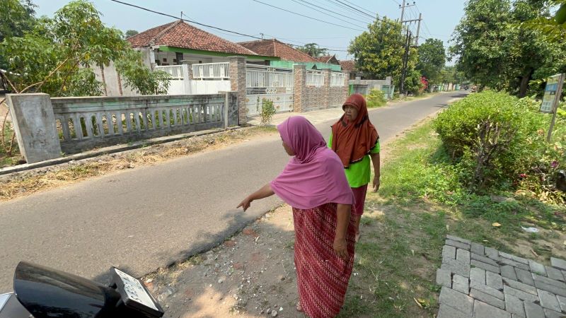CELAKA: Warga menunjukkan lokasi nenek Kayi tergeletak usai terkena peluru nyasar di teras rumahnya.