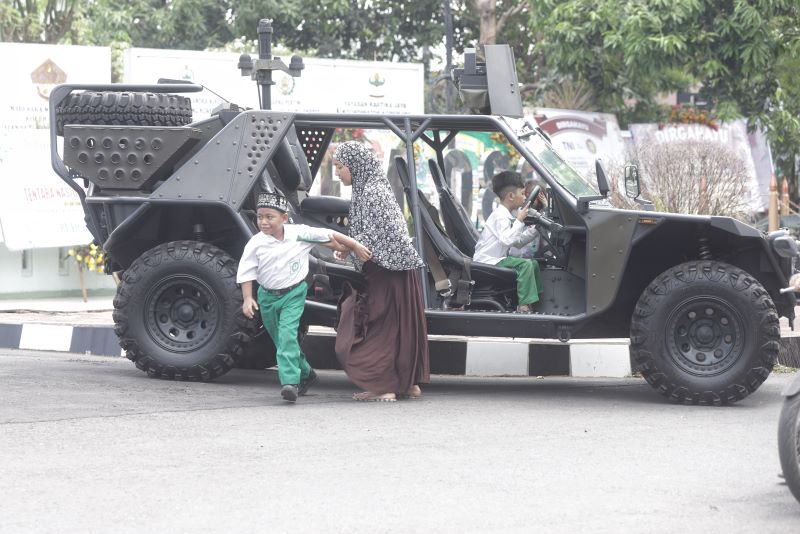 ALUSISTA: Warga berswafoto di atas kendaraan militer di depan Makorem 082/CPYJ Jalan Hasyim Asy
