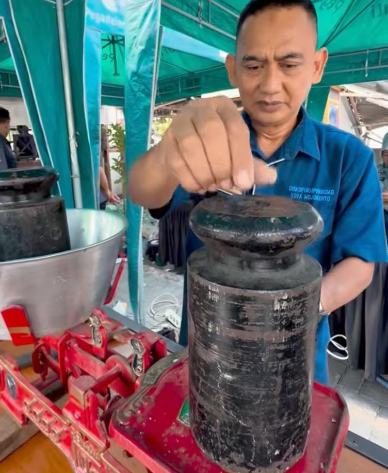 DISESUAIKAN TAKARAN: Petugas melakukan tera ulang terhadap UTTP di Pasar Tradisional Prajurit Kulon, Kota Mojokerto, Selasa (7/10).