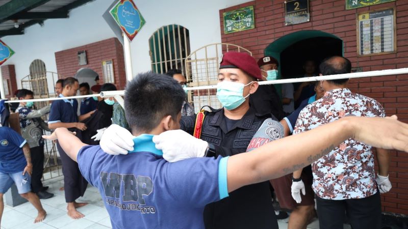 MENJAGA INTEGRITAS: Petugas lapas dan Polres Mojokerto Kota menggeledah satu persatu barang milik napi dan tahanan saat razia insidentil pada Jumat (10/10).